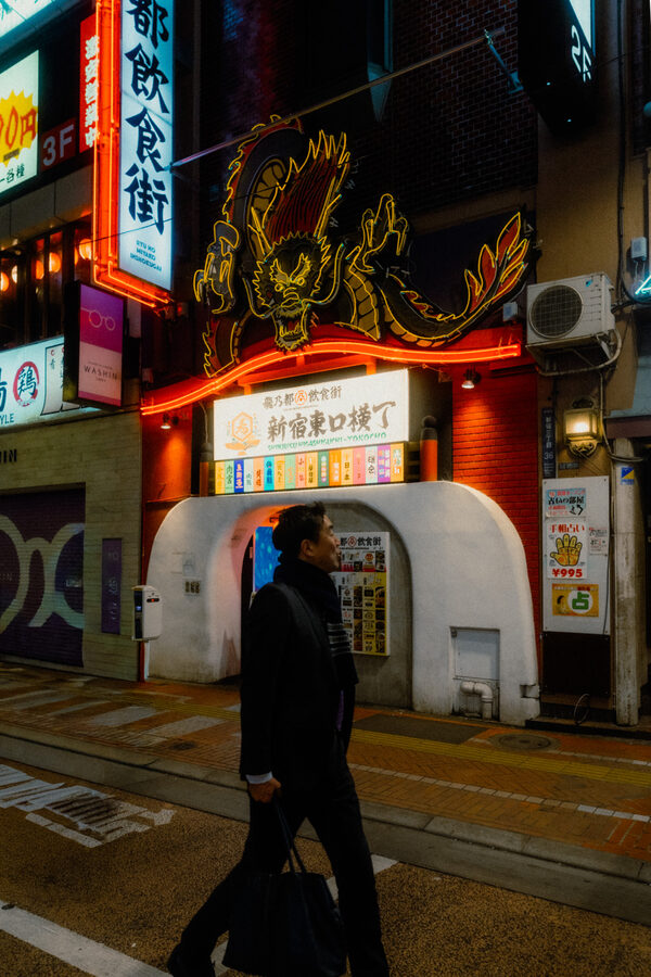 Cammino sotto l'insegna, street photography a Tokyo