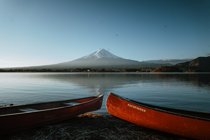 Due canoe rosse riposano sulla riva davanti al Monte Fuji