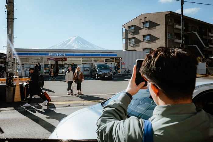 Un viaggiatore fotografa il Monte Fuji davanti alla stazione di Fujiyoshida