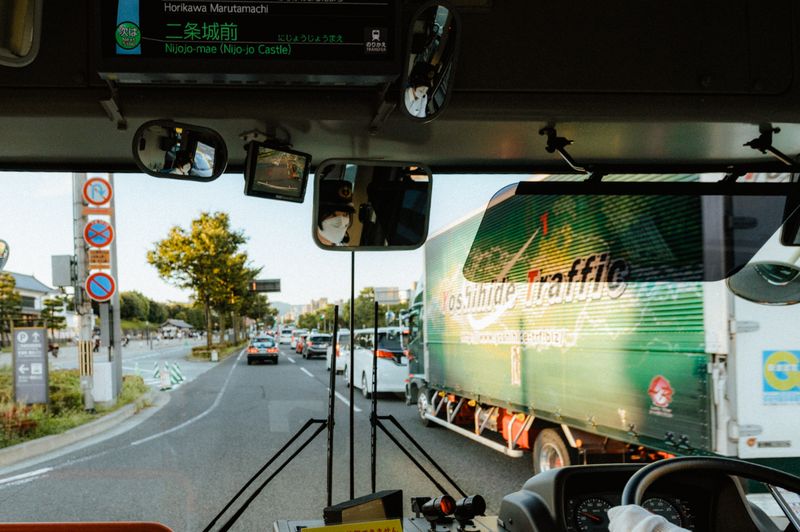 Interno di un autobus urbano diretto a Nijō-jō, autista con mascherina riflesso nello specchietto, Kyoto