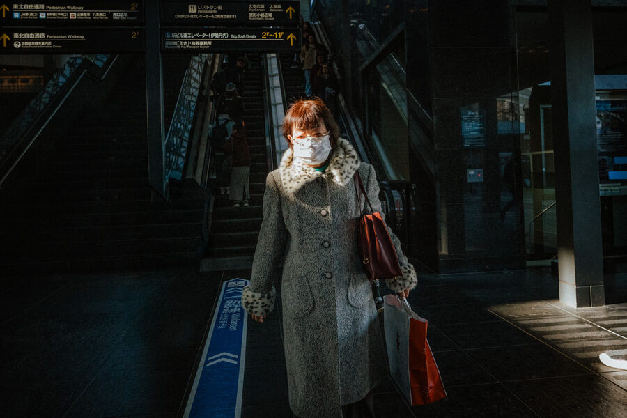 Donna con mascherina attraversa una zona in ombra, Kyoto