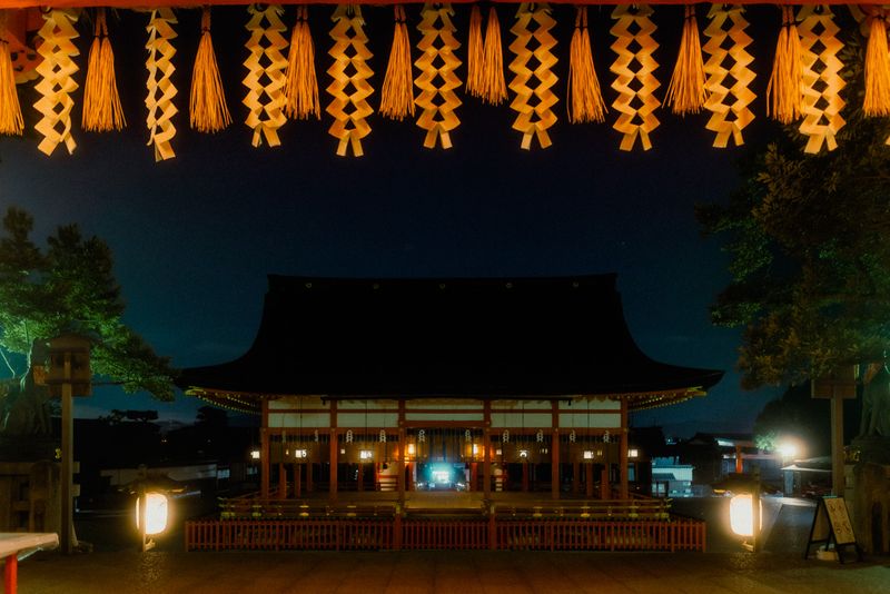 La sala principale di Fushimi Inari incorniciata dagli shide di paglia intrecciata, di notte, Kyoto