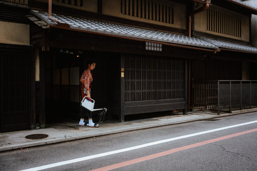 Donna passa davanti alla facciata di una machiya tradizionale, Kyoto