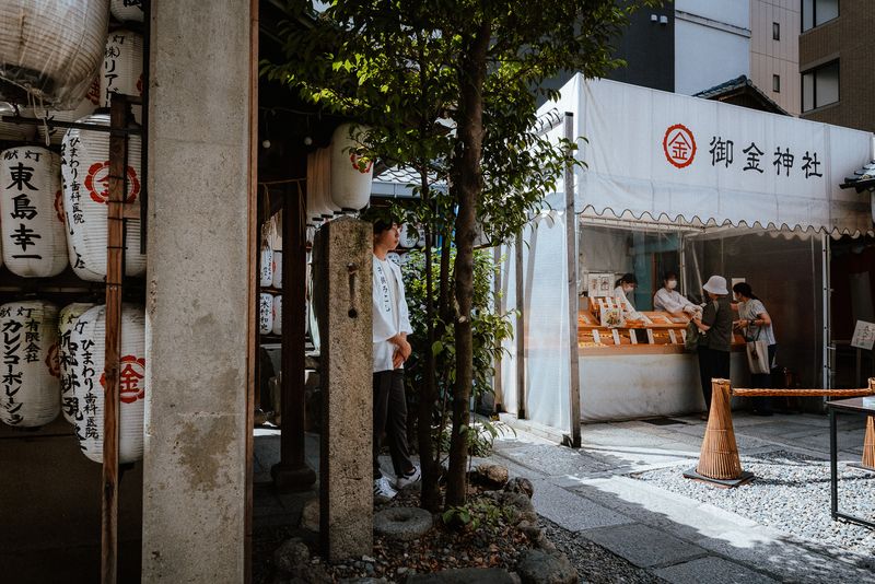 Fedeli acquistano amuleti al banco del santuario Mikane tra le lanterne, Kyoto
