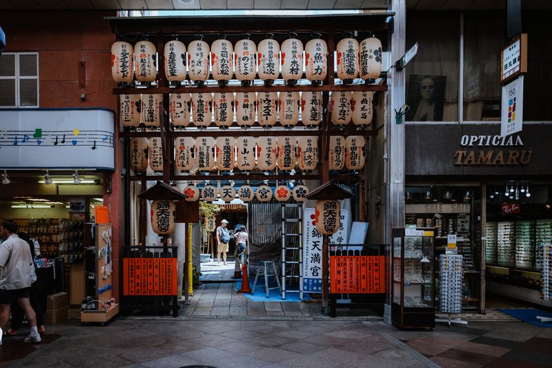 Ingresso del santuario Nishiki Tenmangū incorniciato da tre file di lanterne bianche votive, Kyoto
