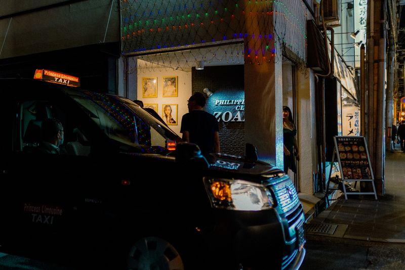 Un taxi Princess Limousine davanti a un club illuminato di notte, Kyoto