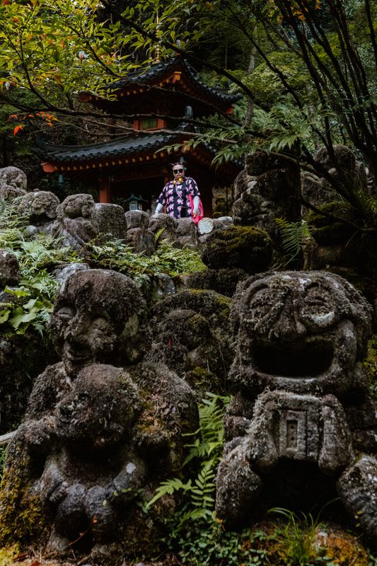 Visitatrice in rosa tra le statue rakan sotto un padiglione, Otagi Nenbutsu-ji, Kyoto