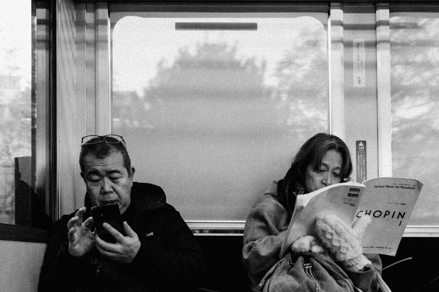Passeggeri leggono durante il viaggio in treno, Kyoto