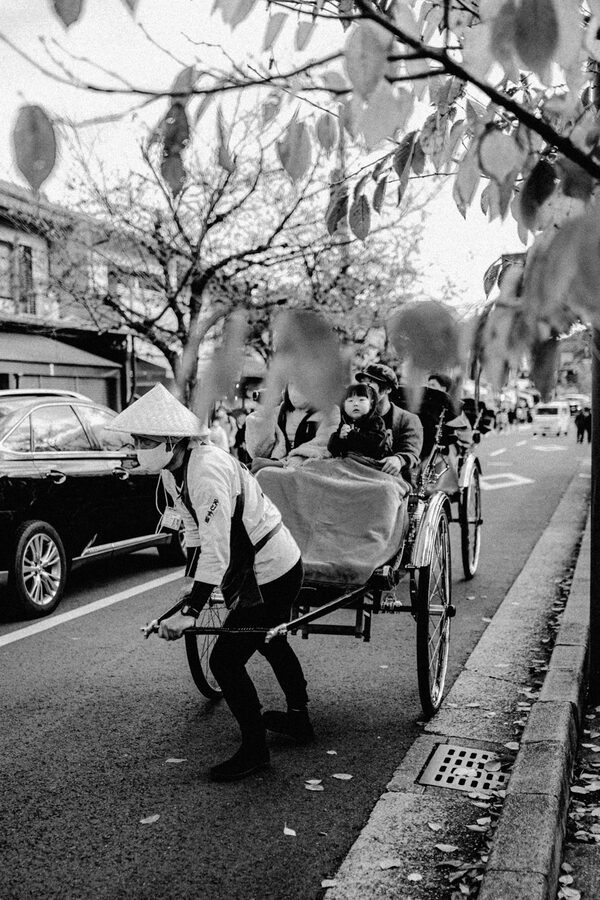Risciò con passeggeri in una strada tradizionale, bianco e nero, Kyoto
