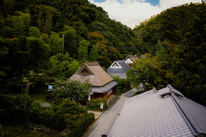 Casa dal tetto di paglia in una valle verde tra i monti, area di Sagano, Kyoto