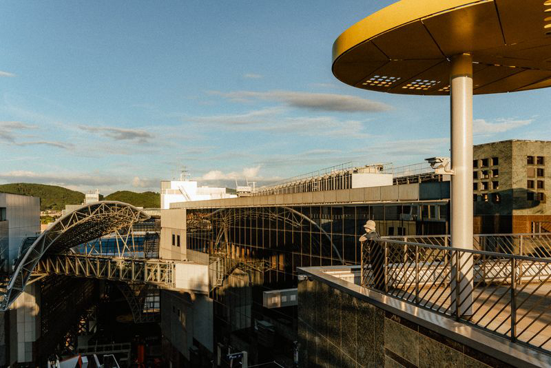 Terrazza panoramica della stazione di Kyoto con una figura alla ringhiera al tramonto, Kyoto