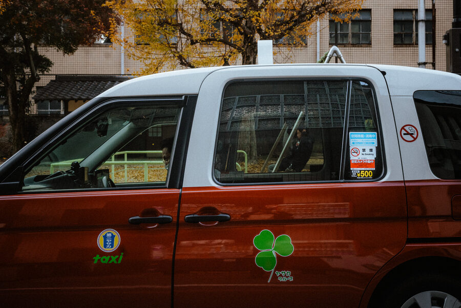 Taxi bicolore fermo lungo una strada di Kyoto