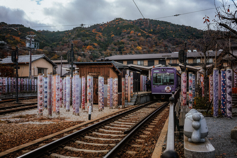 Treno Randen in una stazione decorata dai colori autunnali, Kyoto