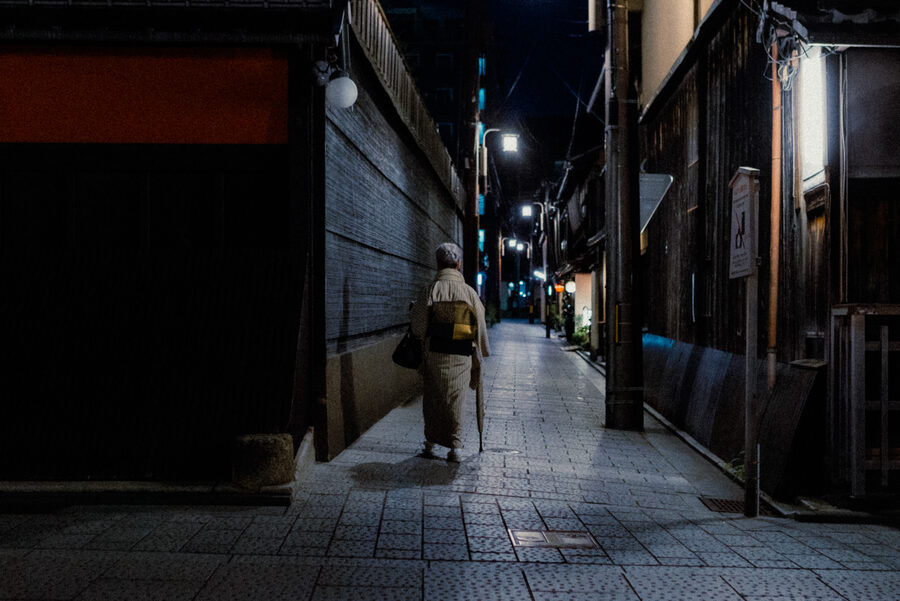 Figura solitaria cammina in uno stretto vicolo di Kyoto