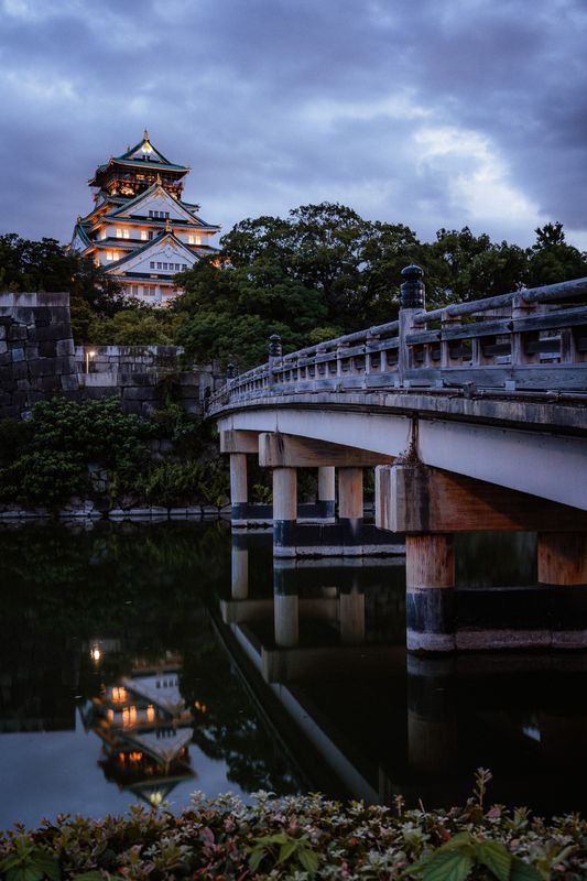 Il castello di Osaka illuminato al crepuscolo con il ponte e il riflesso nel fossato, Osaka