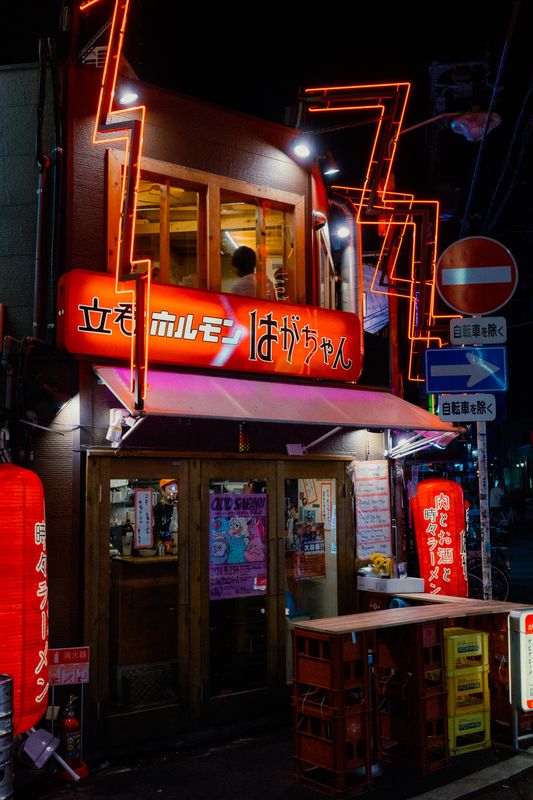Locale di horumon in piedi con l'insegna rossa e il neon a zigzag che incornicia la facciata, Osaka