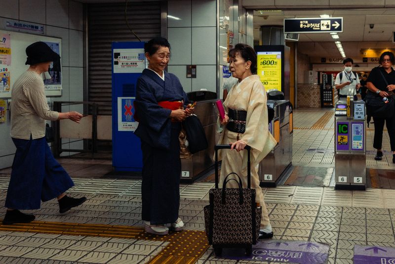Due signore in kimono conversano davanti ai tornelli della stazione di Namba, Osaka