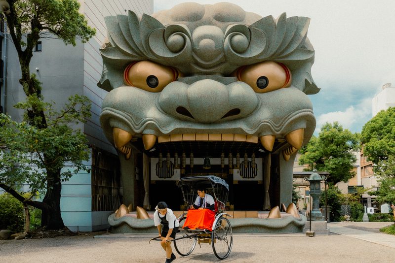 Risciò davanti alla testa di leone gigante del santuario Namba Yasaka, Osaka