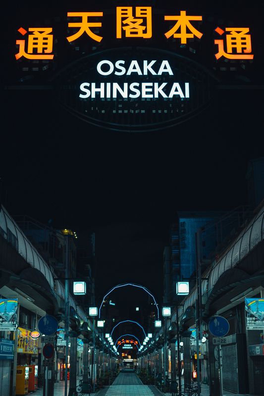 L'arco d'ingresso illuminato di Shinsekai sulla galleria deserta a notte fonda, Osaka