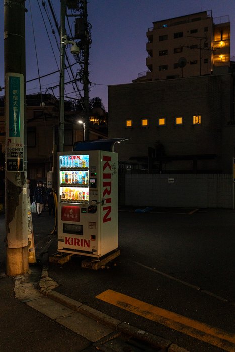 Un distributore automatico illumina una strada laterale al calare della sera, Tokyo