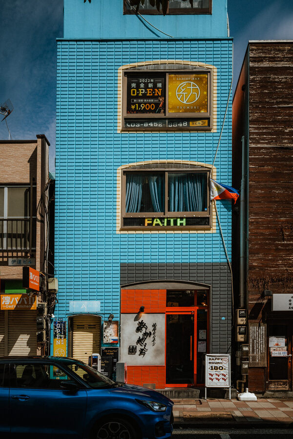 Piccolo edificio blu e automobile in una strada di Tokyo