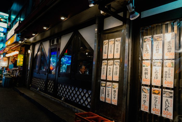 Le pareti esterne di un izakaya coperte di menu scritti a mano, Tokyo