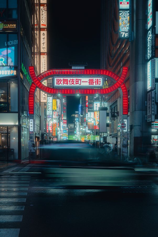 L’arco luminoso rosso all’ingresso di Kabukichō Ichiban-gai con il traffico mosso in lunga esposizione, Tokyo