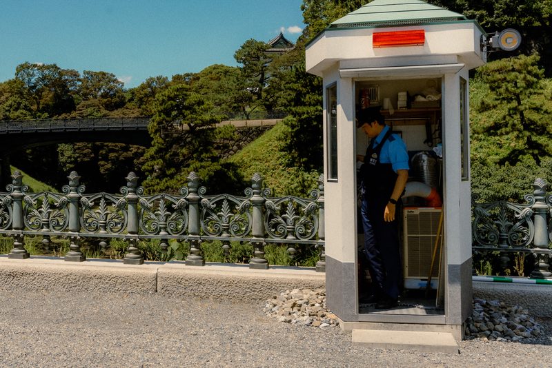 Poliziotto in una garitta accanto al ponte del Palazzo Imperiale, di giorno, Tokyo