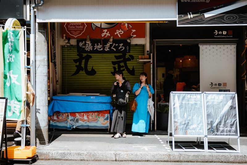 Due donne mangiano un gelato davanti alla pescheria di tonno Marutake, mercato di Tsukiji, Tokyo