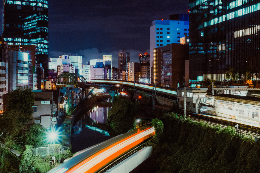 Scia luminosa di un treno sopra il canale e i binari di Ochanomizu, Tokyo