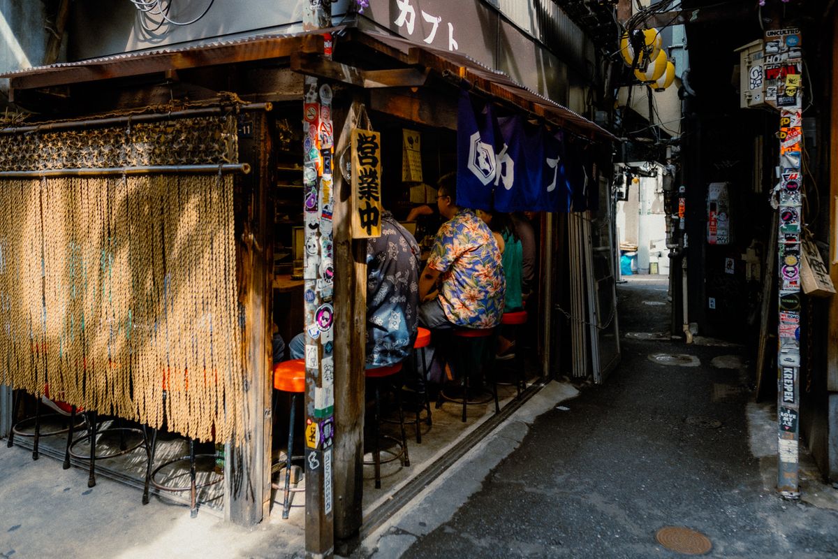 Avventori al banco di una izakaya nel vicolo di Omoide Yokochō, Shinjuku, Tokyo