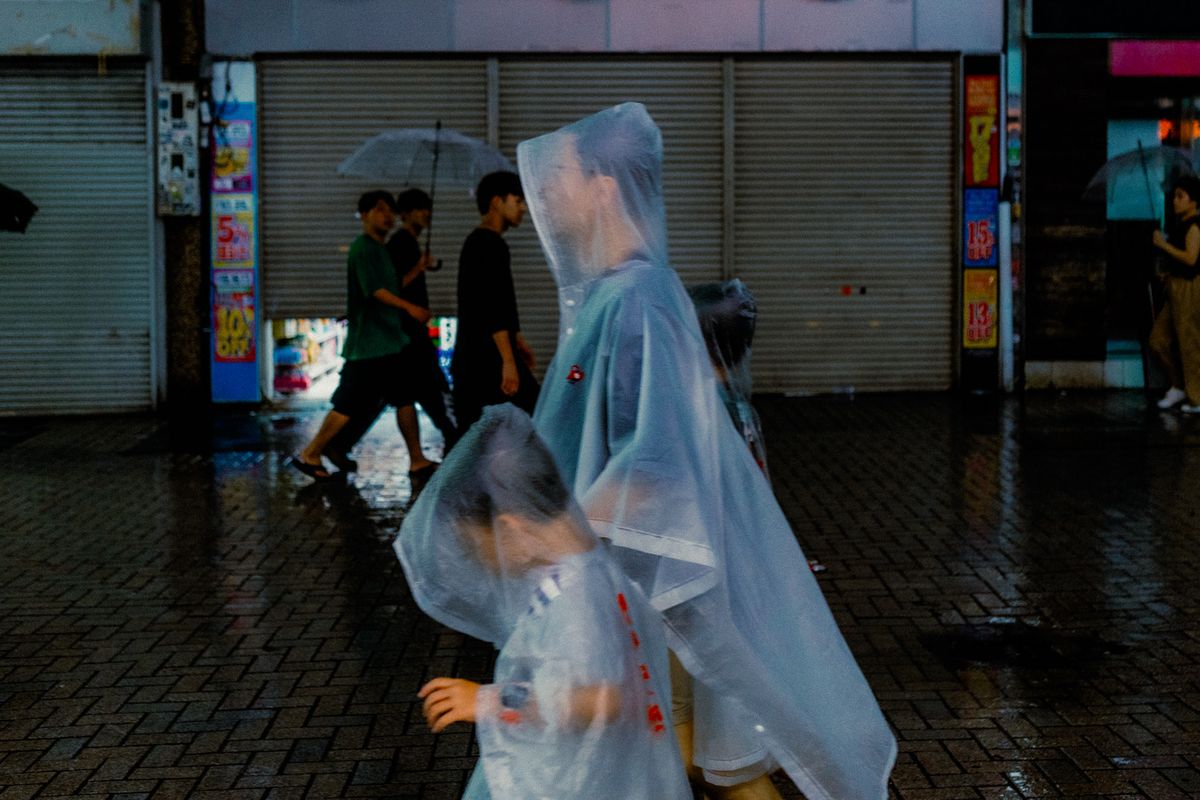 Passanti con poncho trasparenti sotto la pioggia, Tokyo