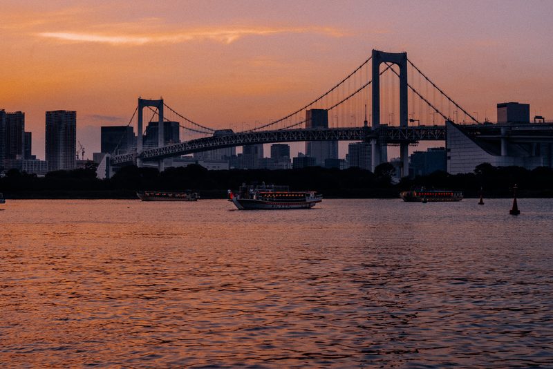 Il Rainbow Bridge al tramonto con le barche yakatabune, baia di Tokyo
