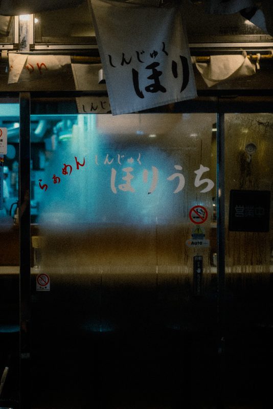 Vetro appannato di un ramen-ya con scritte e riflessi azzurri, di notte, Shinjuku, Tokyo