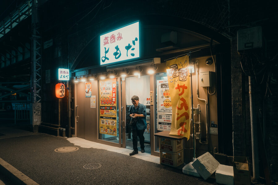 Uomo davanti all’ingresso illuminato di un piccolo ristorante, Tokyo