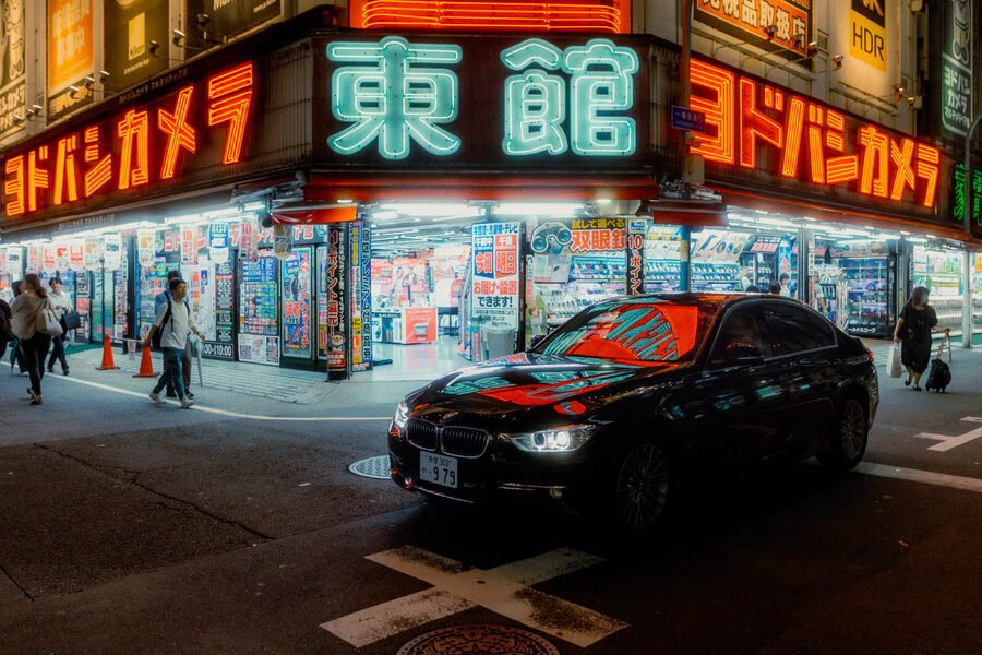 BMW ferma davanti alla facciata luminosa di Yodobashi Camera, Shinjuku, Tokyo