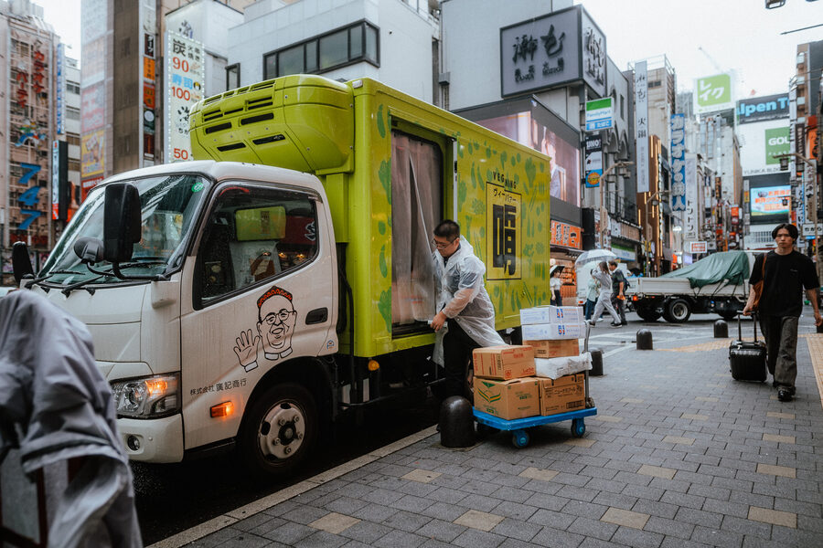 Furgone delle consegne e cassette sul bordo di una strada di Shinjuku, Tokyo