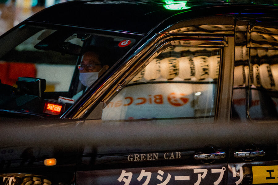 Autista di Green Cab incorniciato dai riflessi delle lanterne sul finestrino, Shinjuku, Tokyo