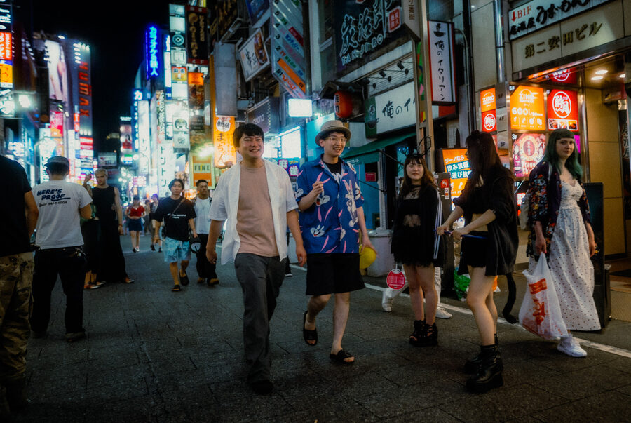 Gruppo di giovani attraversa una strada affollata di Kabukichō, Shinjuku, Tokyo