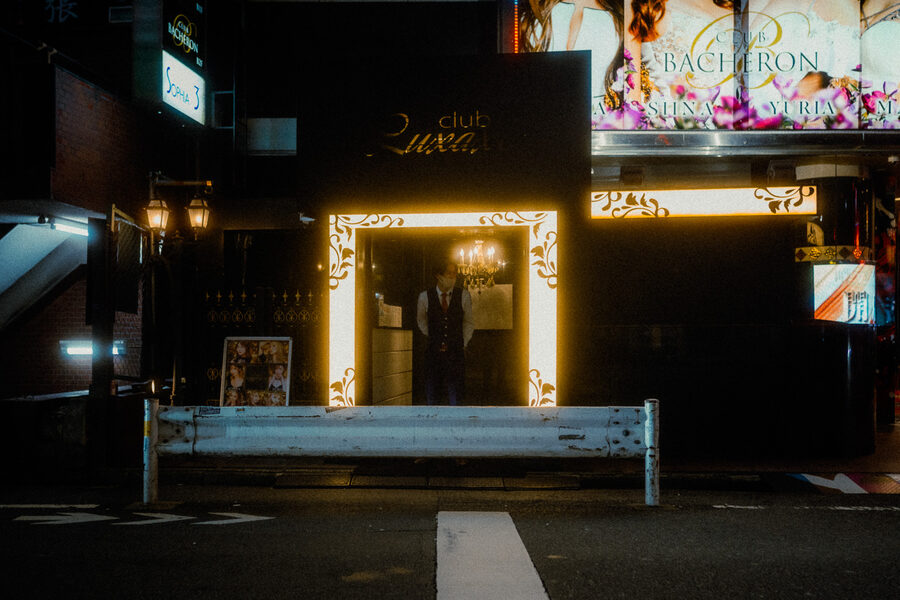 Portiere in gilet attende nell’ingresso dorato di un host club, Shinjuku, Tokyo