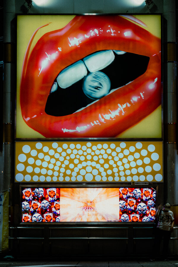 Grande insegna luminosa con labbra rosse domina una facciata notturna, Shinjuku, Tokyo