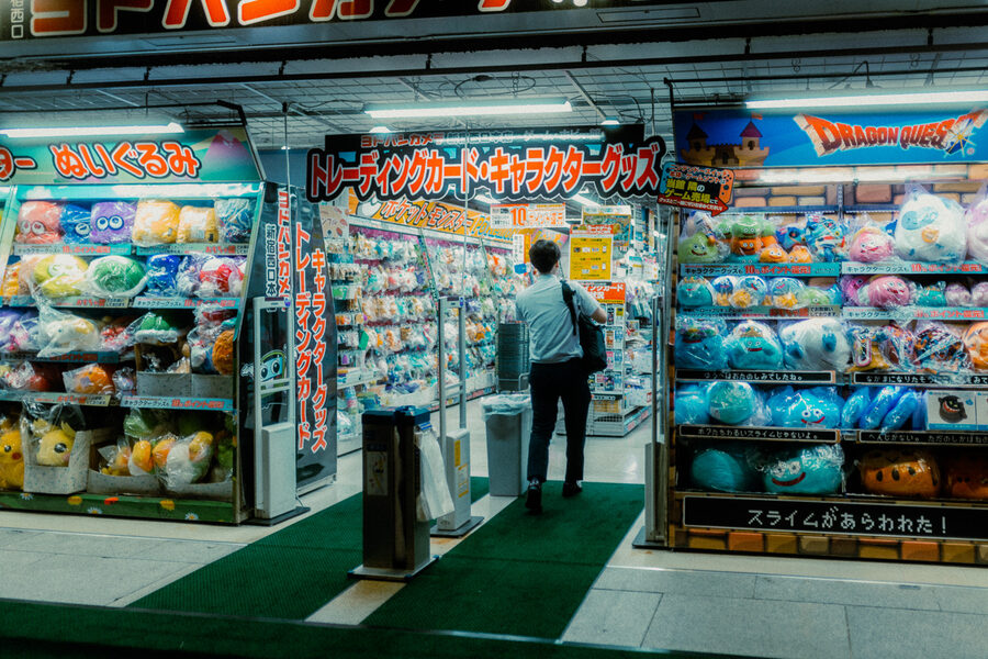 Cliente entra in un negozio colmo di peluche e character goods, Shinjuku, Tokyo
