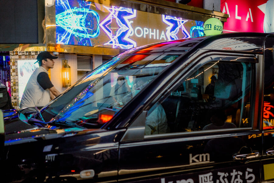 Taxi nero con insegne di Kabukichō riflesse sulla fiancata, Shinjuku, Tokyo