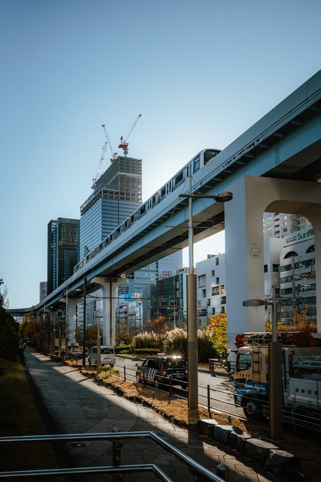Una strada sopraelevata corre verso un grattacielo nel cielo limpido di Tokyo