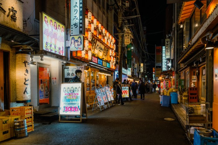 Una strada di izakaya e insegne luminose nel quartiere notturno di Tokyo
