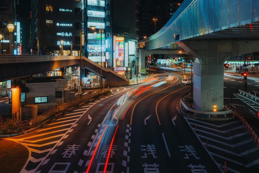 Scie luminose delle auto su un incrocio visto dall’alto sotto la sopraelevata, notte, Tokyo
