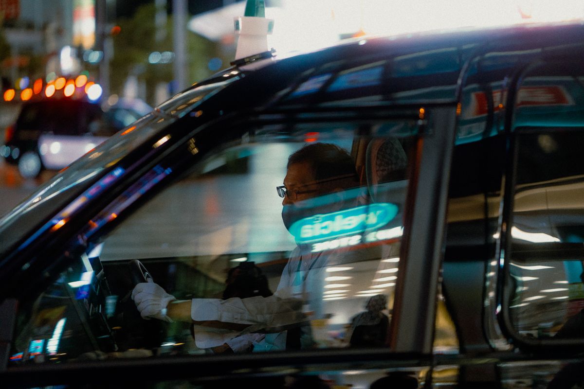 Tassista con i guanti bianchi al volante, visto dal finestrino, Tokyo