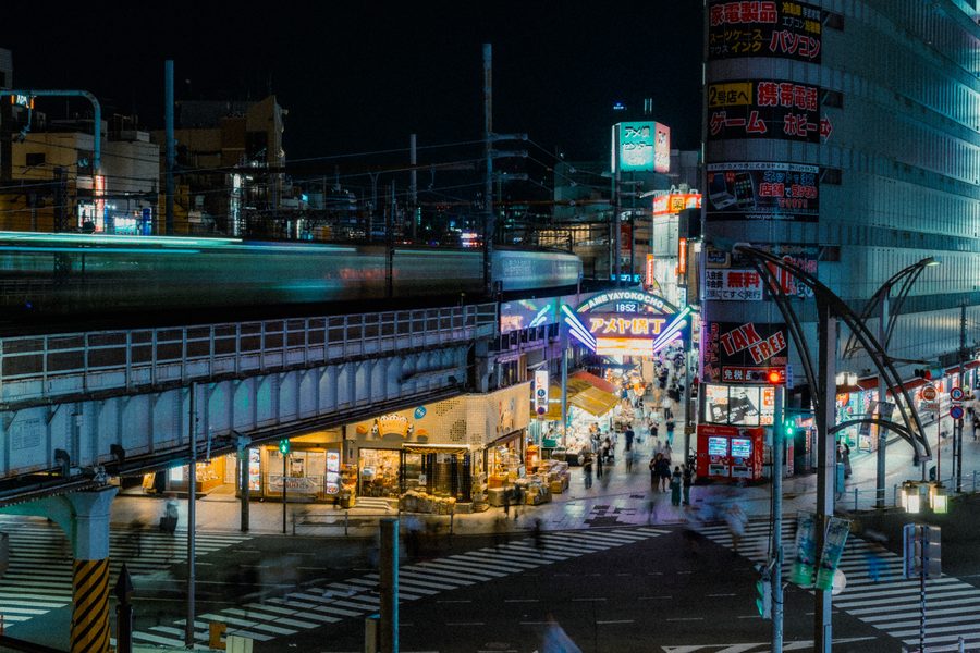 Veduta dall’alto dell’ingresso di Ameya-Yokochō di notte, con il treno mosso sulla sopraelevata, Ueno, Tokyo