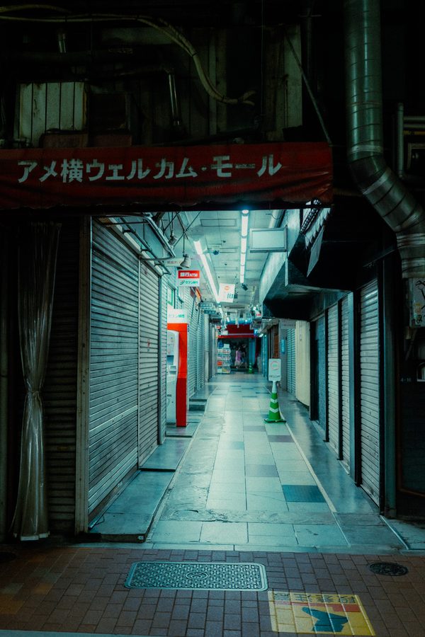 Galleria dell’Ameyoko Welcome Mall con le saracinesche abbassate e una luce fredda in fondo, Ueno, Tokyo