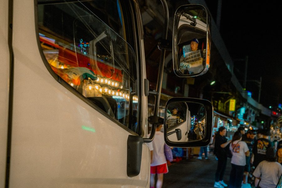 Il volto dell’autista riflesso negli specchietti di un camion bianco fermo nella via del mercato, di notte, Ueno, Tokyo